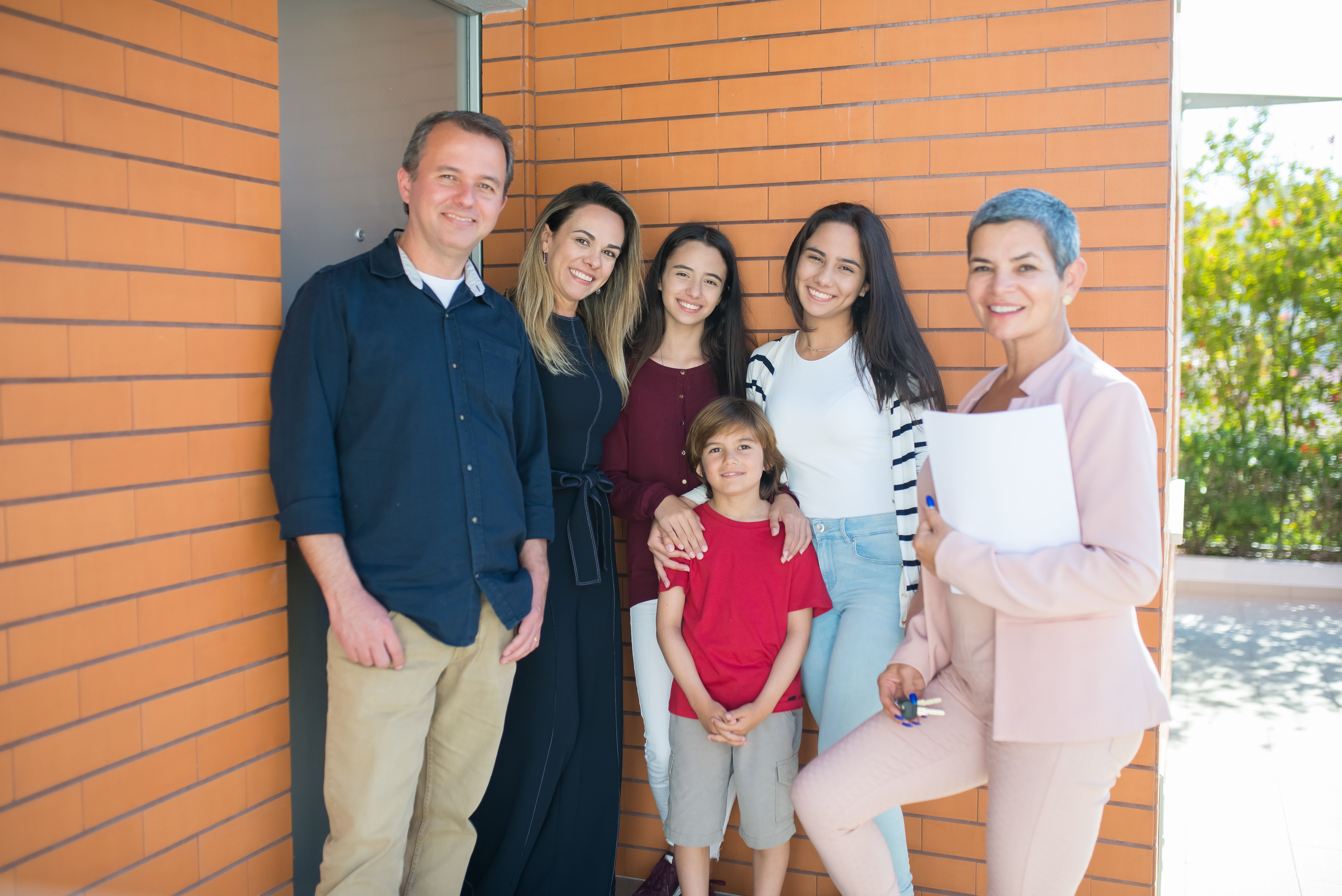 An agent handing house keys to a happy family on closing day